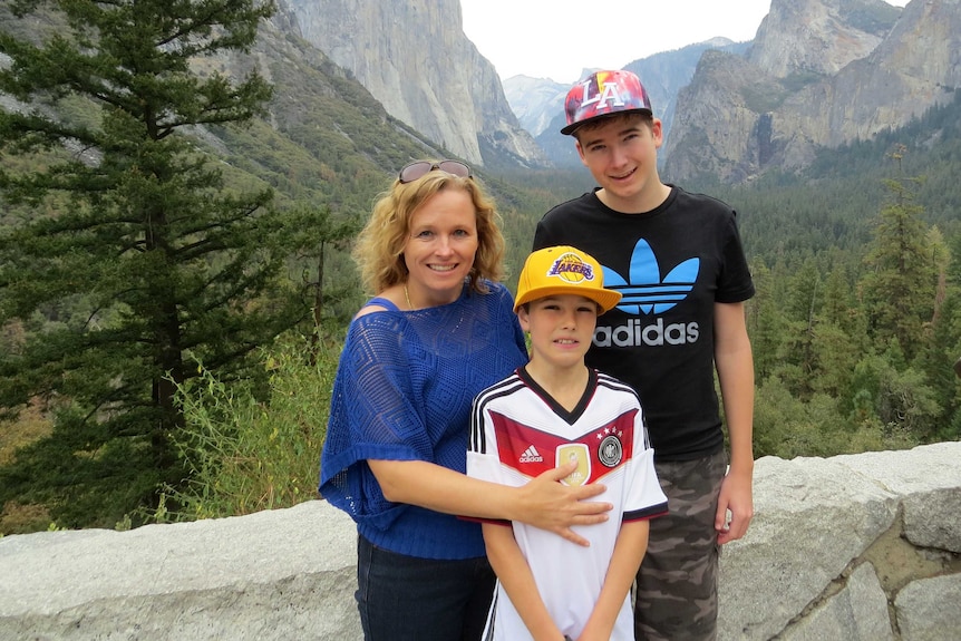 Dyslexia support advocate Tanya Forbes and her sons Brendan and Connor against a mountainous backdrop.