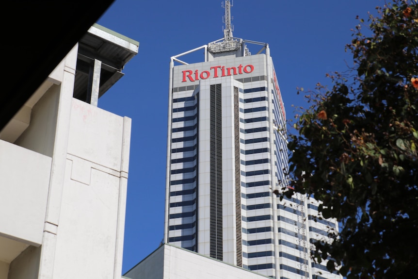 The Rio Tinto building external framed by another building and tree.