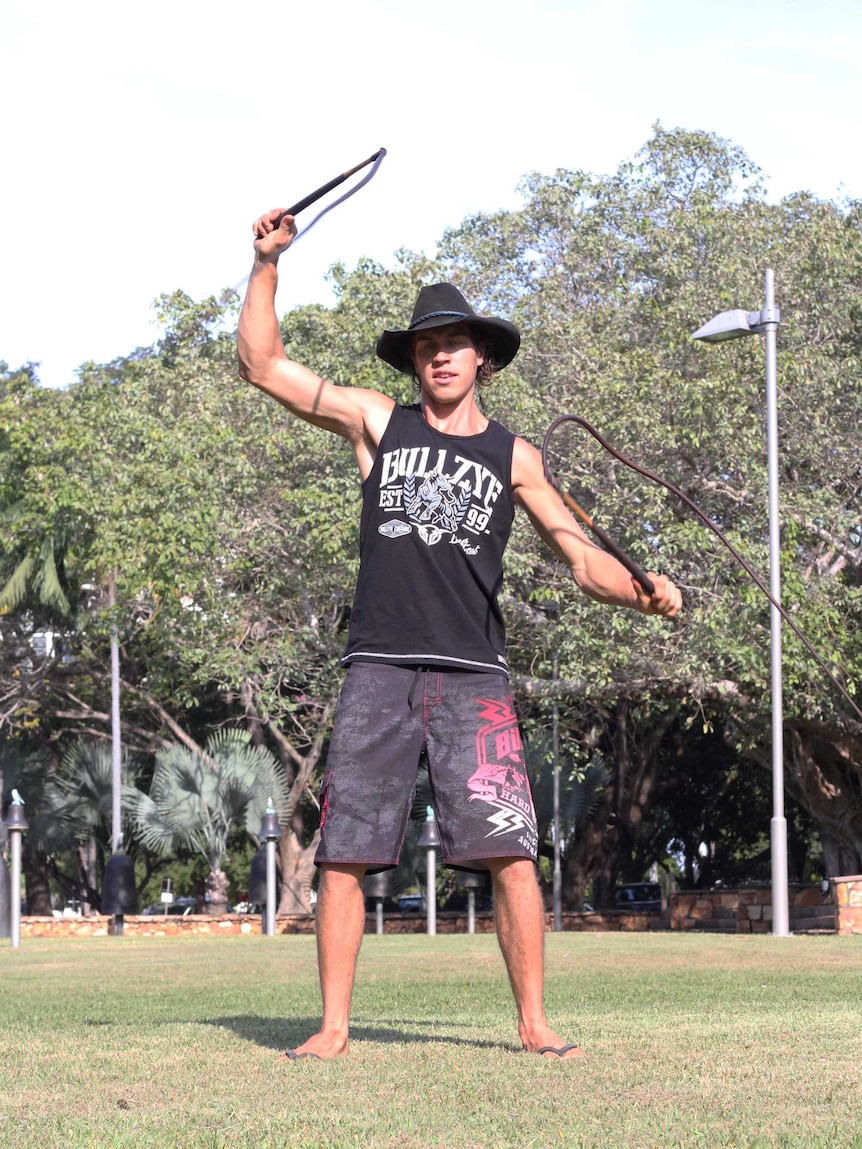 A man in a hat with whips around his neck.