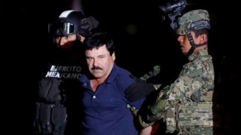 El Chapo is held by heavily armed Mexican police.
