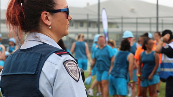 Prison officer watching on as inmates at Brisbane Women's Correctional Centre get ready to run in the background