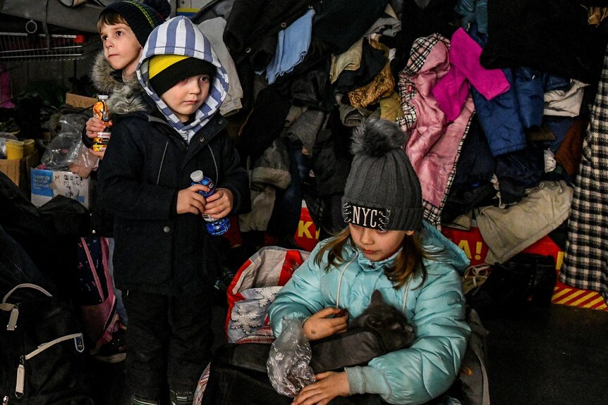 Children rest at a collecting point after fleeing from Mariupol.