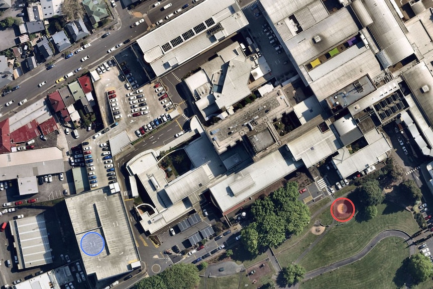 A satellite view of a hospital with a location highlighted far left on top of a car park..