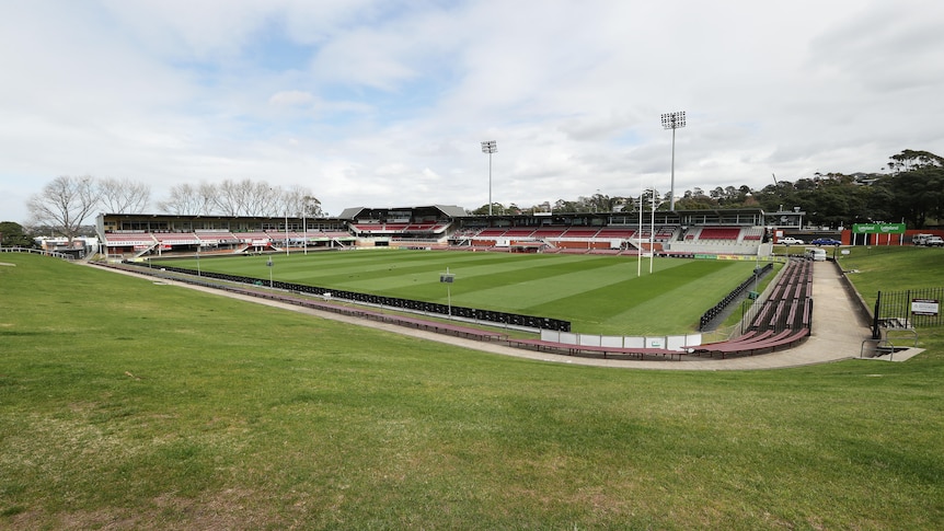 A picture looking down from the hill overlooking an empty Brookvale Oval, across the ground towards the grandstands.