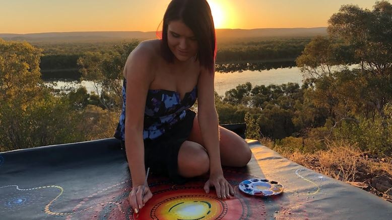 Indigenous artist Chern'ee Sutton working on a painting.