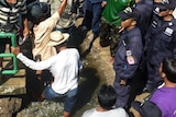 Bangkok residents argue with police as they gather to demand the wider opening of a sluice gate in Bangkok