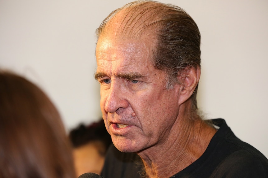 James Ricketson, pictured from the side, mid speech, with a serious expression on his face.