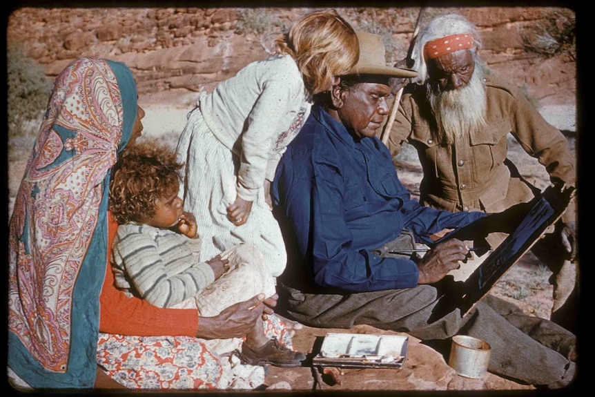 Albert Namatjira painting in the desert with father Jonathon, wife Rubina and grandchildren.