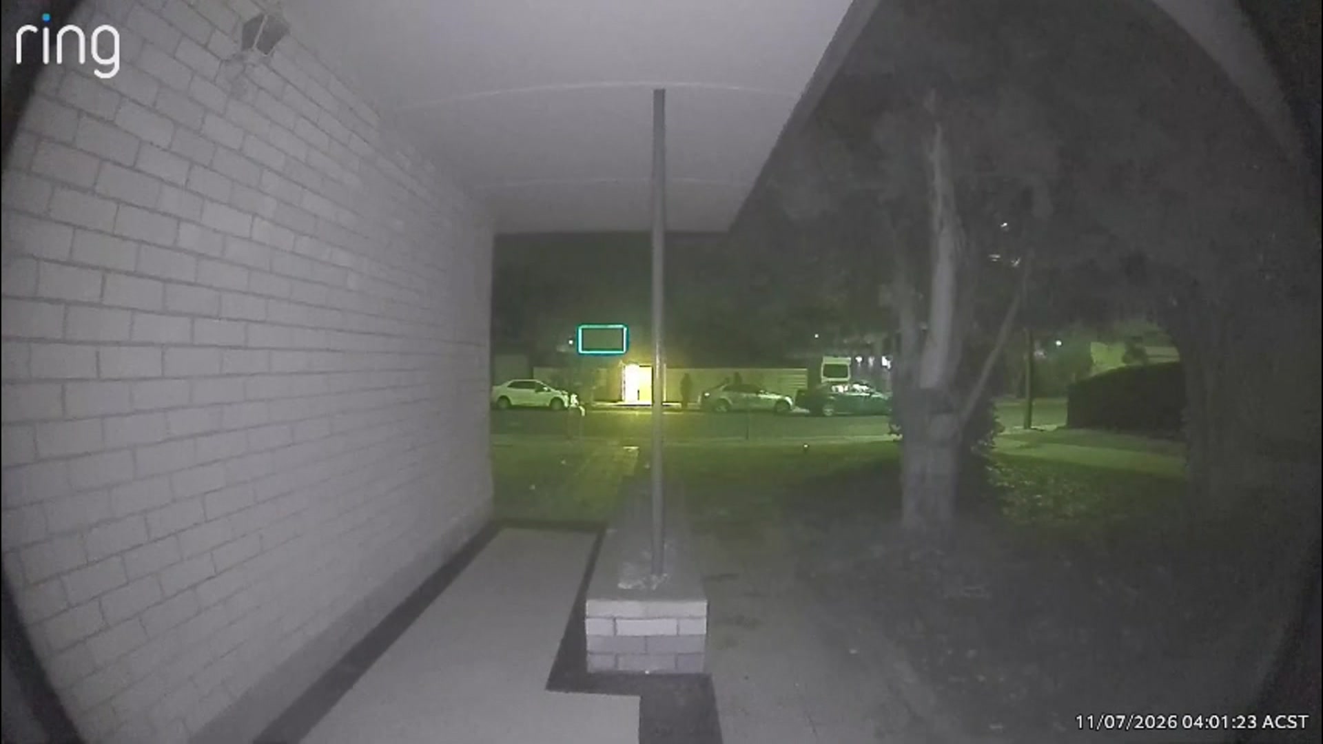 CCTV vision from across the st where you can see two white cars and a dark car, with a figure walking towards the house