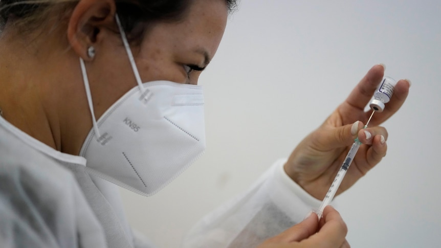 A nurse prepares a dose of the Pfizer coronavirus vaccine
