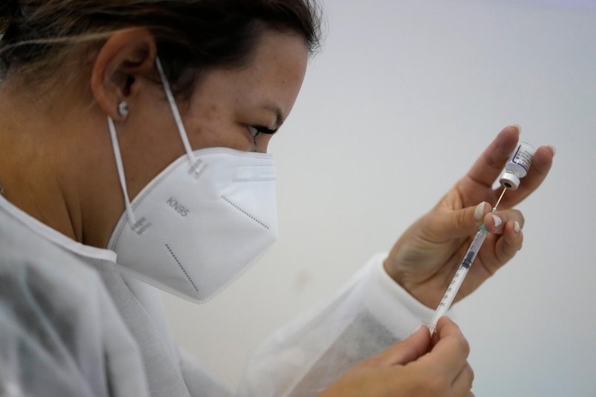 A nurse prepares a dose of the Pfizer coronavirus vaccine