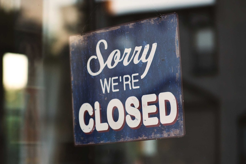 Sorry we're closed sign hanging on glass door, a reminder to close old unused bank accounts once establishing new ones.