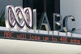 A news headlines ticker reporting on job cuts at the ABC