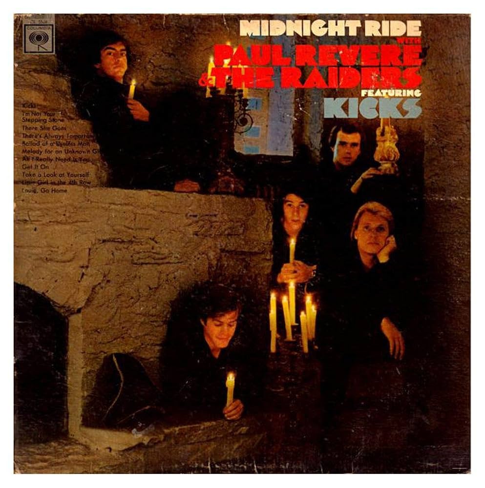 The band members sit in an old stone building by candlelight
