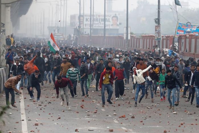 Demonstrators throw rock in New Delhi.
