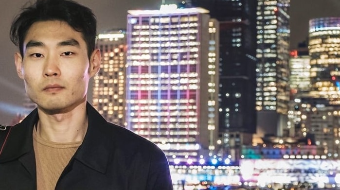 Picture of David Park standing with city scape behind him. The picture is taken at night
