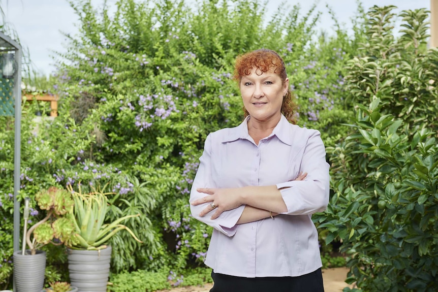 Nicci Wall stands in a garden.