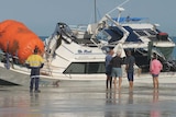 Image of a damaged boat sitting in low water off the coast of Cable Beach.