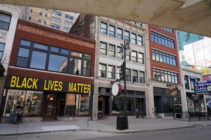 A line of buildings, one with Black Lives Matter written at the front, alongside a street.