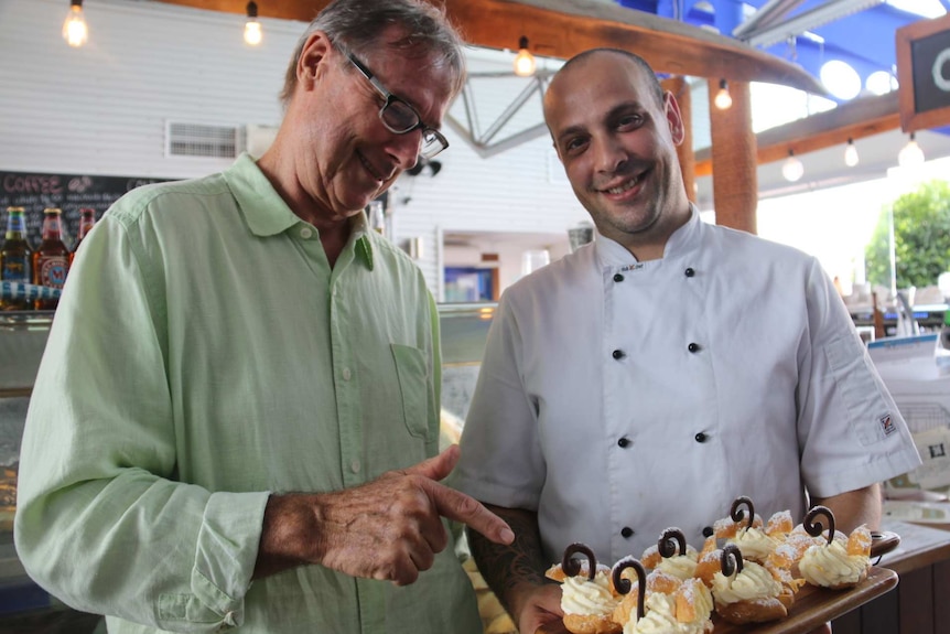 Boat shed Coffee House owner John Bonnin stands with and Italian baker Angelo Pinto and some of his pastry delights.