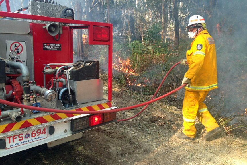 Firefighter at the Lefroy bushfire pulls out a hose during backburning March 5, 2015