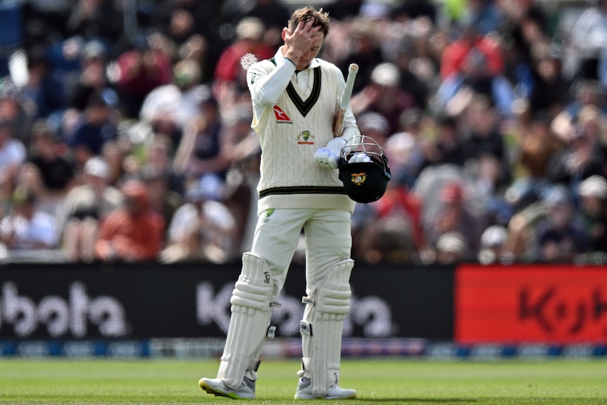 Marnus Labuschagne puts his hand to his head while carrying his batting gear