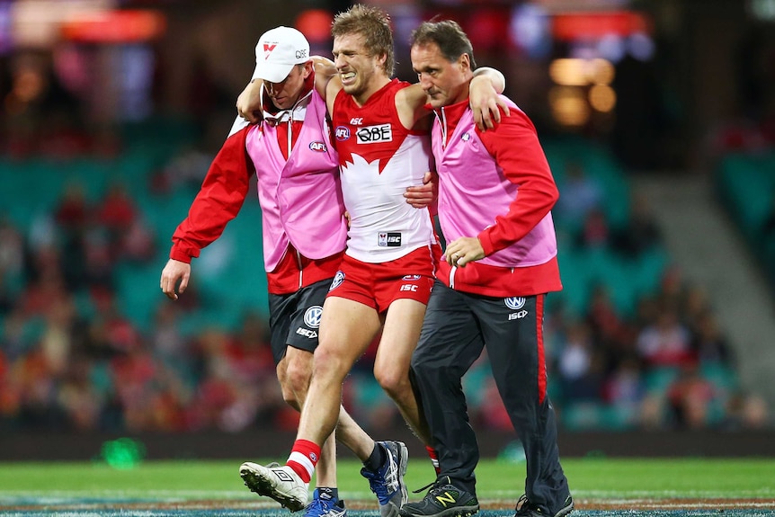 Sydney's Kieren Jack is helped from the field after injuring his knee against Gold Coast.