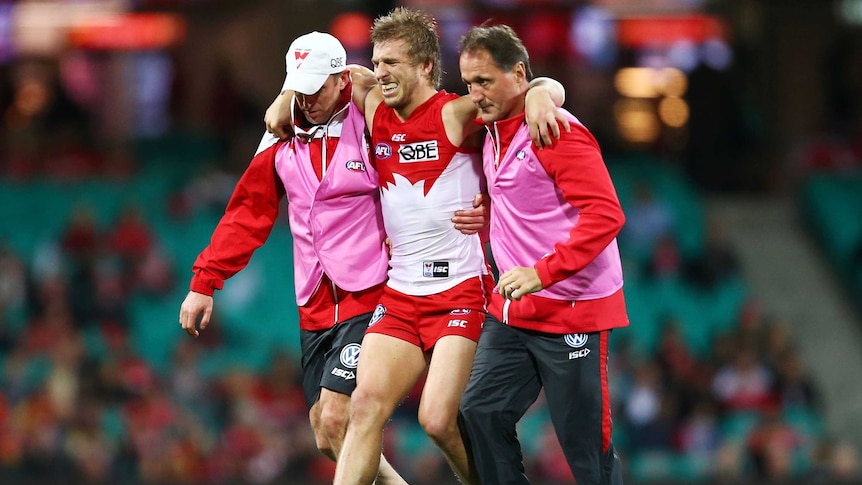 Sydney's Kieren Jack is assisted from the field after a knee injury against Gold Coast at the SCG.