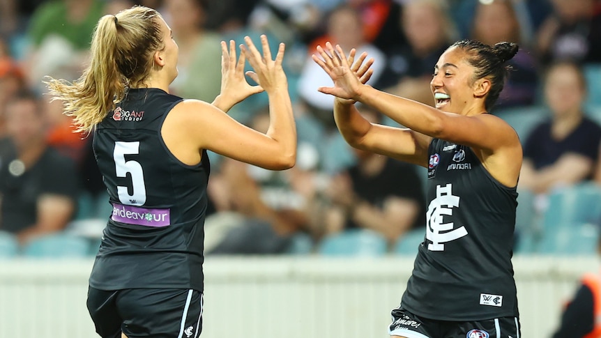 Two Carlton AFLW players celebrate a goal against GWS