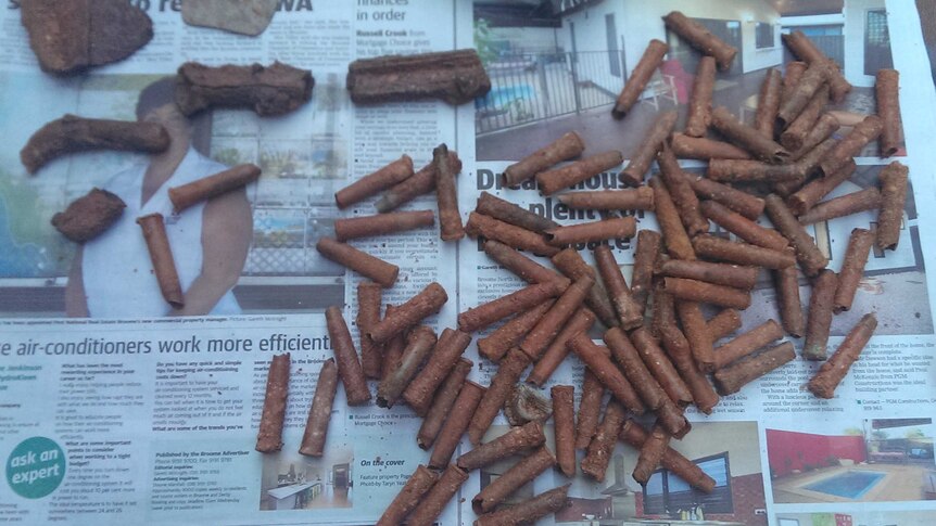 A pile of what looks to be bullets lies on newspaper after being found on a Broome beach