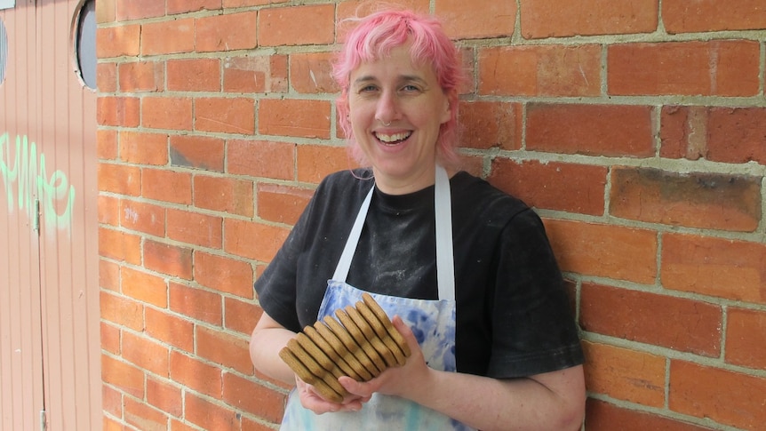 Female baker holding gingerbread biscuits