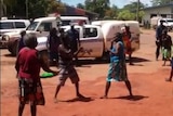 Police watch on while two women fight in Aurukun.