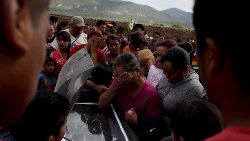 Relatives and friends mourn next to the coffin of one of the pilgrims killed in the truck accident