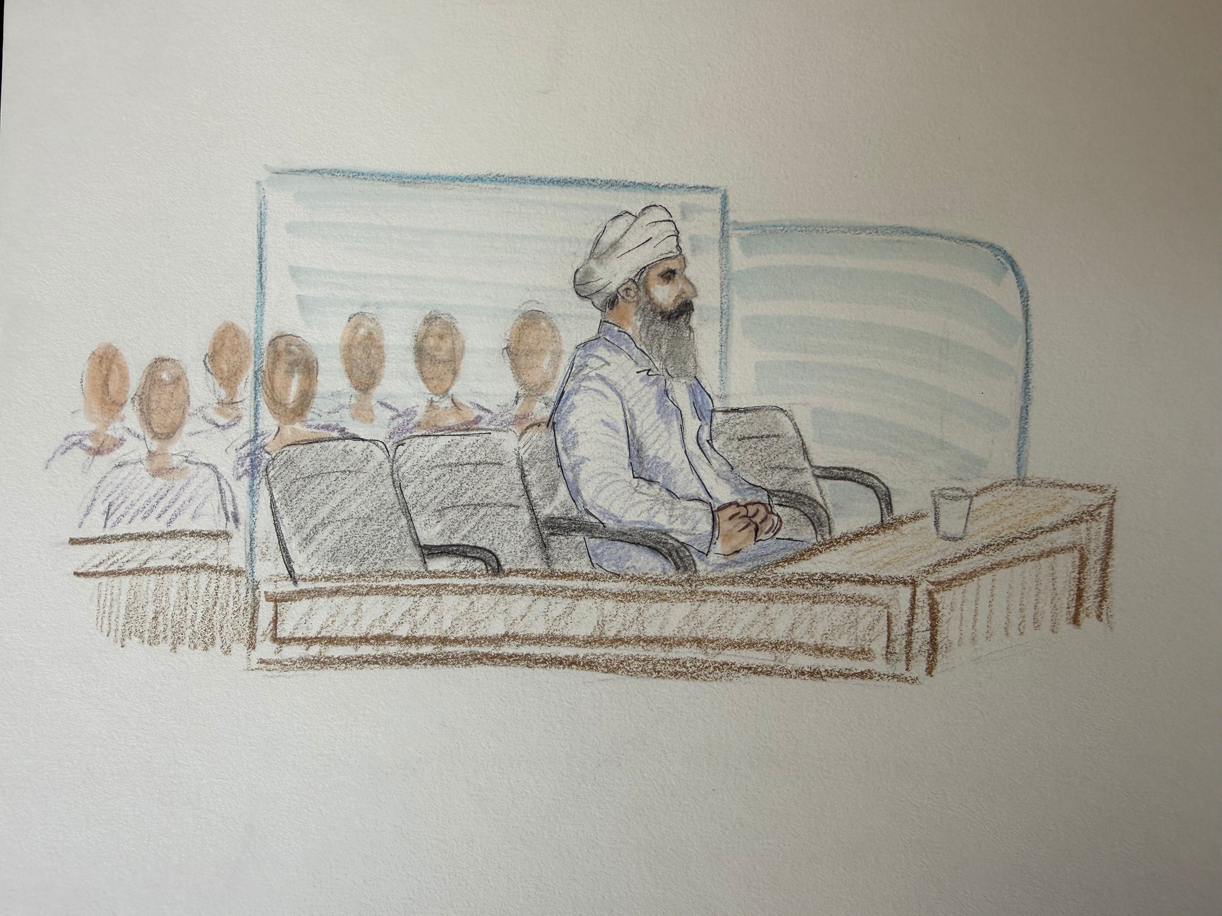 Un boceto de un hombre sij de mediana edad sentado solo en una sala del tribunal.