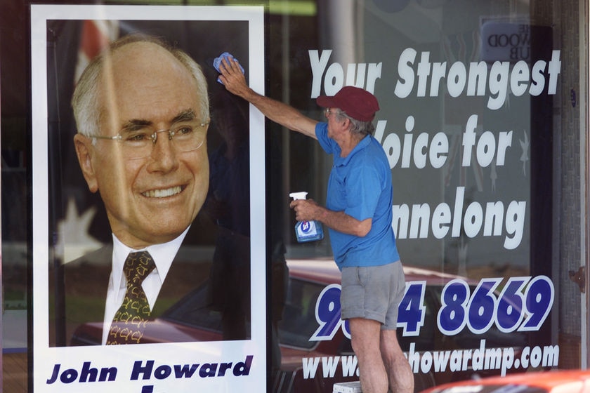 Picture of a cleaner washing down the window of John Howard's electoral office