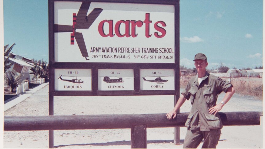 Greg Wirt stands next to an aviation school sign.