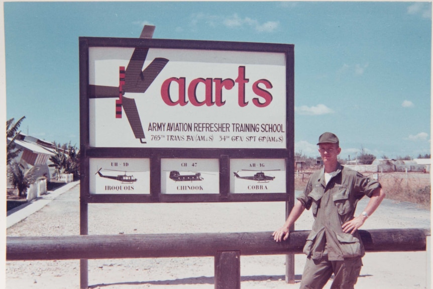 Greg Wirt stands next to an aviation school sign.