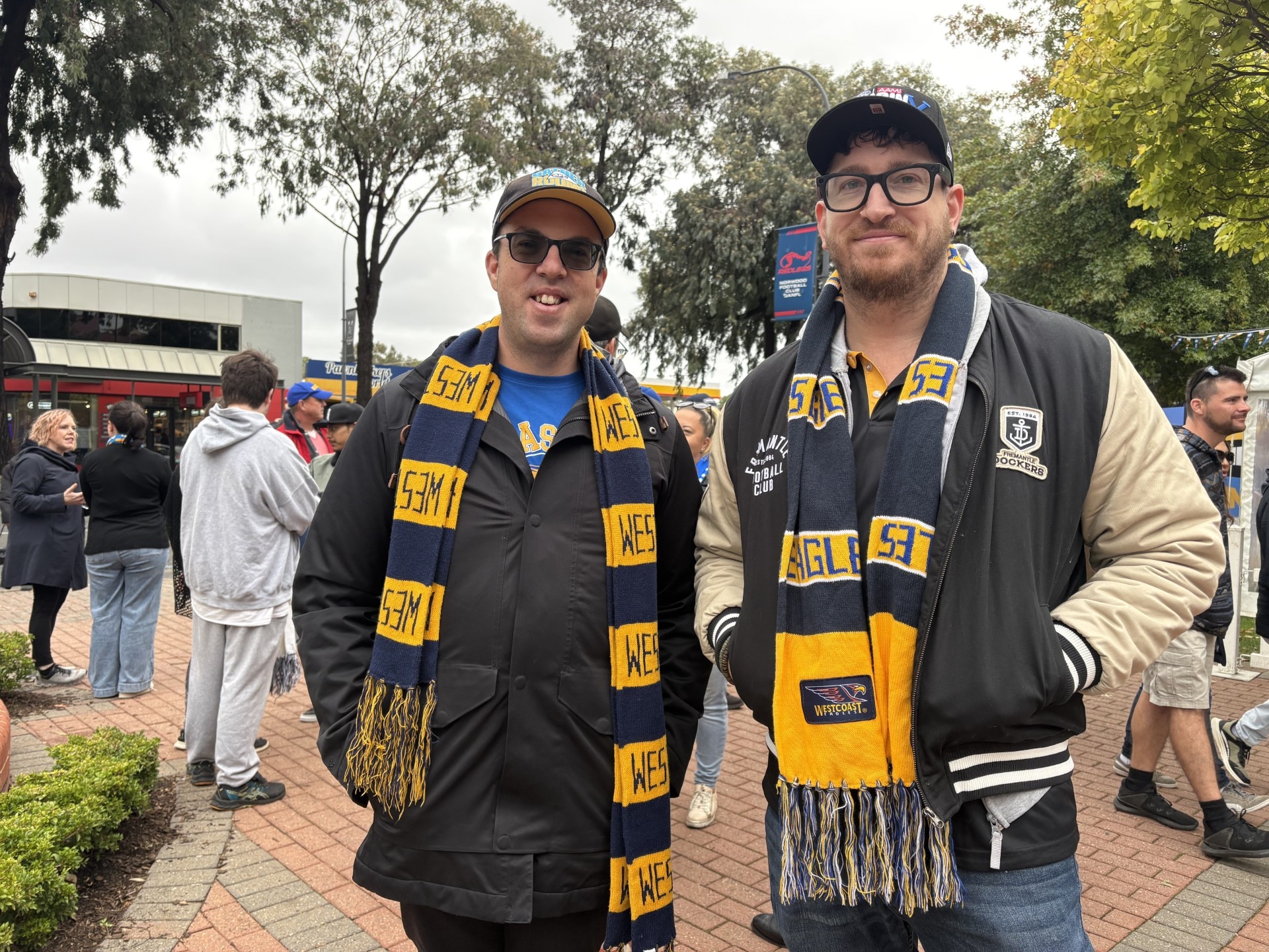 Dois homens com lenços dos Eagles sorriem para a câmera