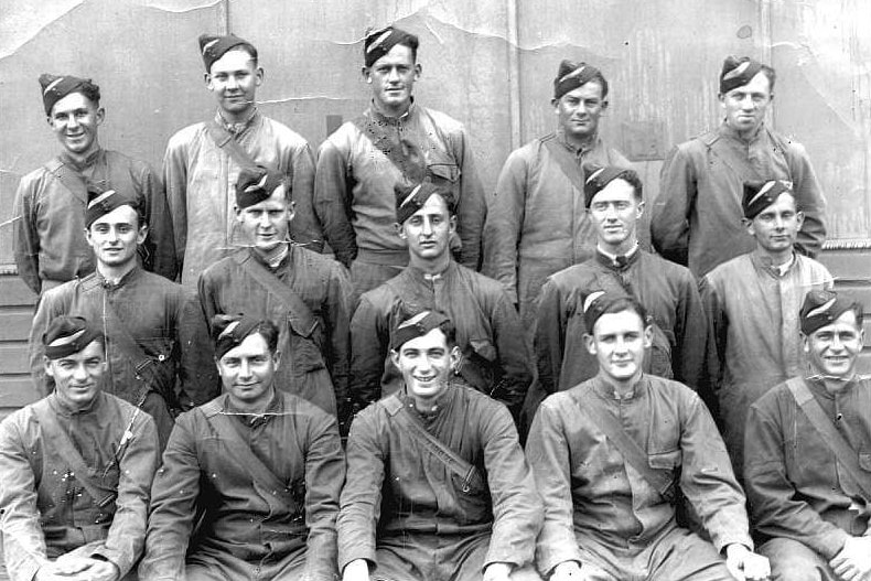 Black and white shot of 15 young men in military uniform.