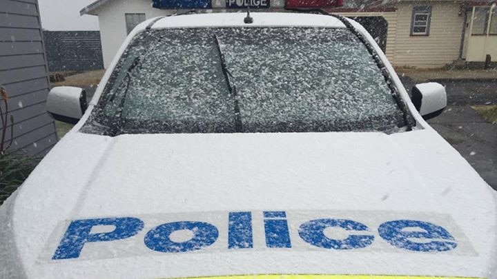 Snow falls on a Tasmania Police car