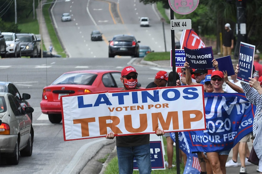 People hold placards on October 10, 2020 in Orlando