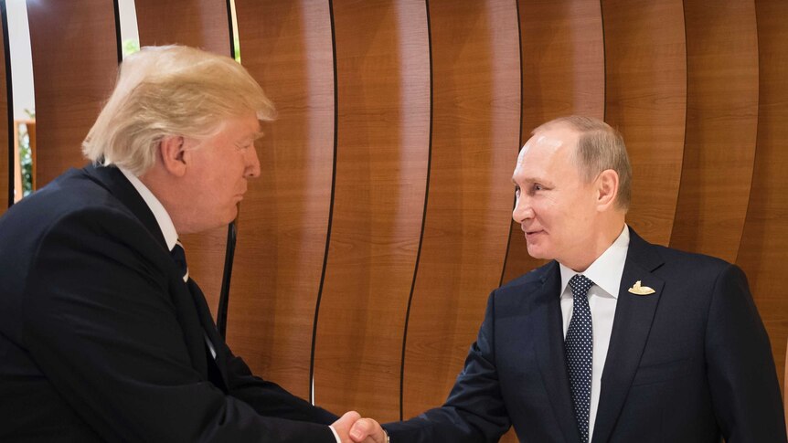 Donald Trump shakes hands with an excited looking Putin in the foyer