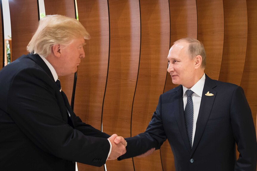 Donald Trump shakes hands with an excited looking putin in the foyer