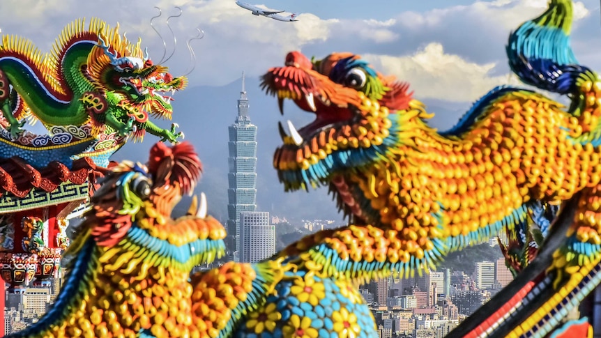 Three colourful Chinese dragons dance, as Taipei 101, the tallest building in Taiwan, is seen in the background.