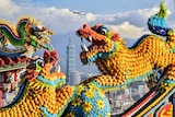 Three colourful Chinese dragons dance, as Taipei 101, the tallest building in Taiwan, is seen in the background.