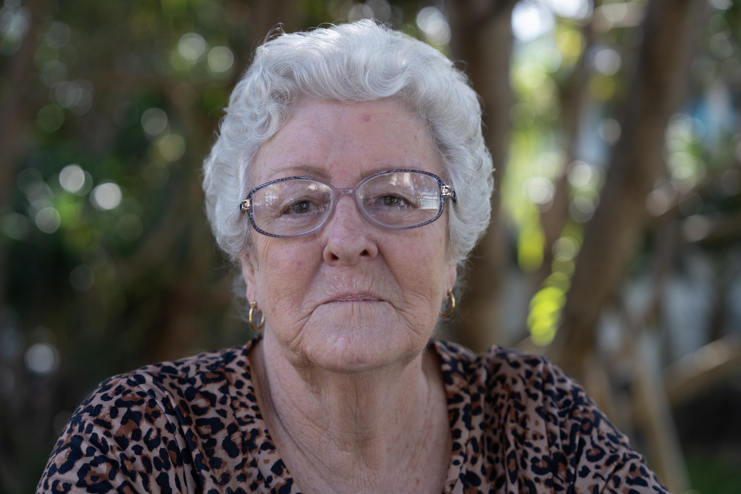 A portrait of a woman with grey hair wearing glasses.