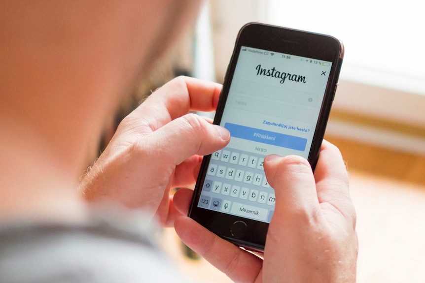 A man uses an iphone to log into instagram.