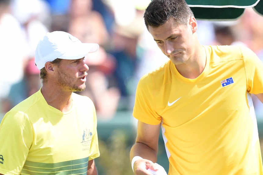 Bernard Tomic speaks to Lleyton Hewitt during the Davis Cup tie against John Isner