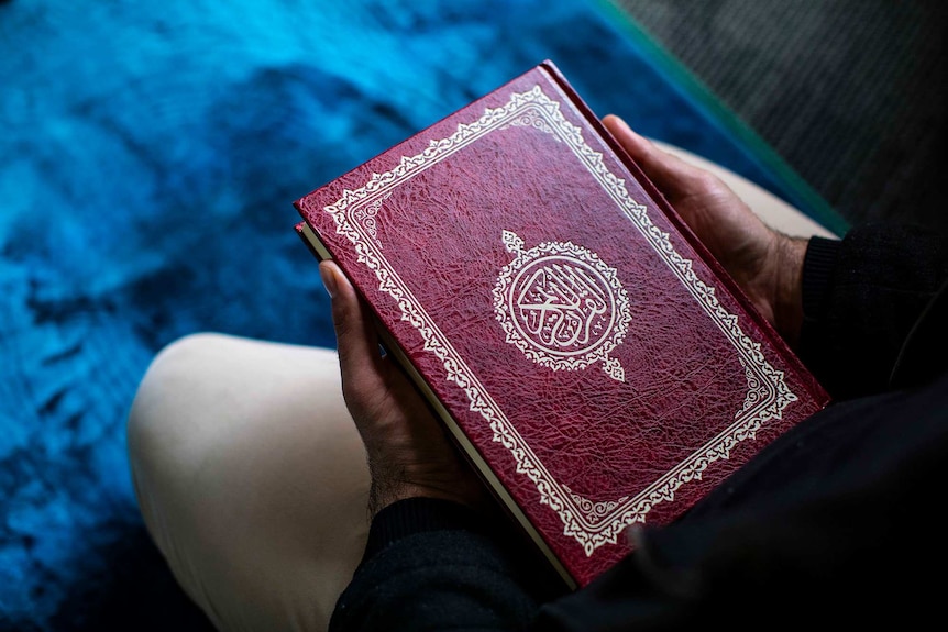 Red Qur'an on prayer mat.