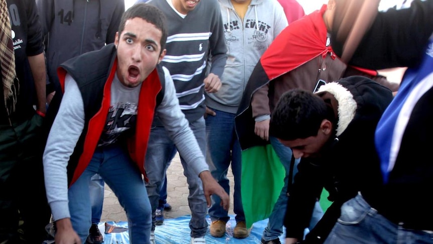 Libyan protesters stomp on a poster of leader Moamar Gaddafi